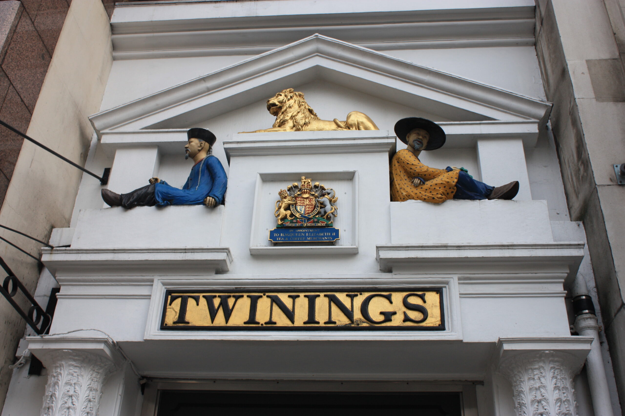 The Twinings Strand shop entrance at 216 Strand, London — the gold Twinings sign with the Royal Warrant coat of arms above it.