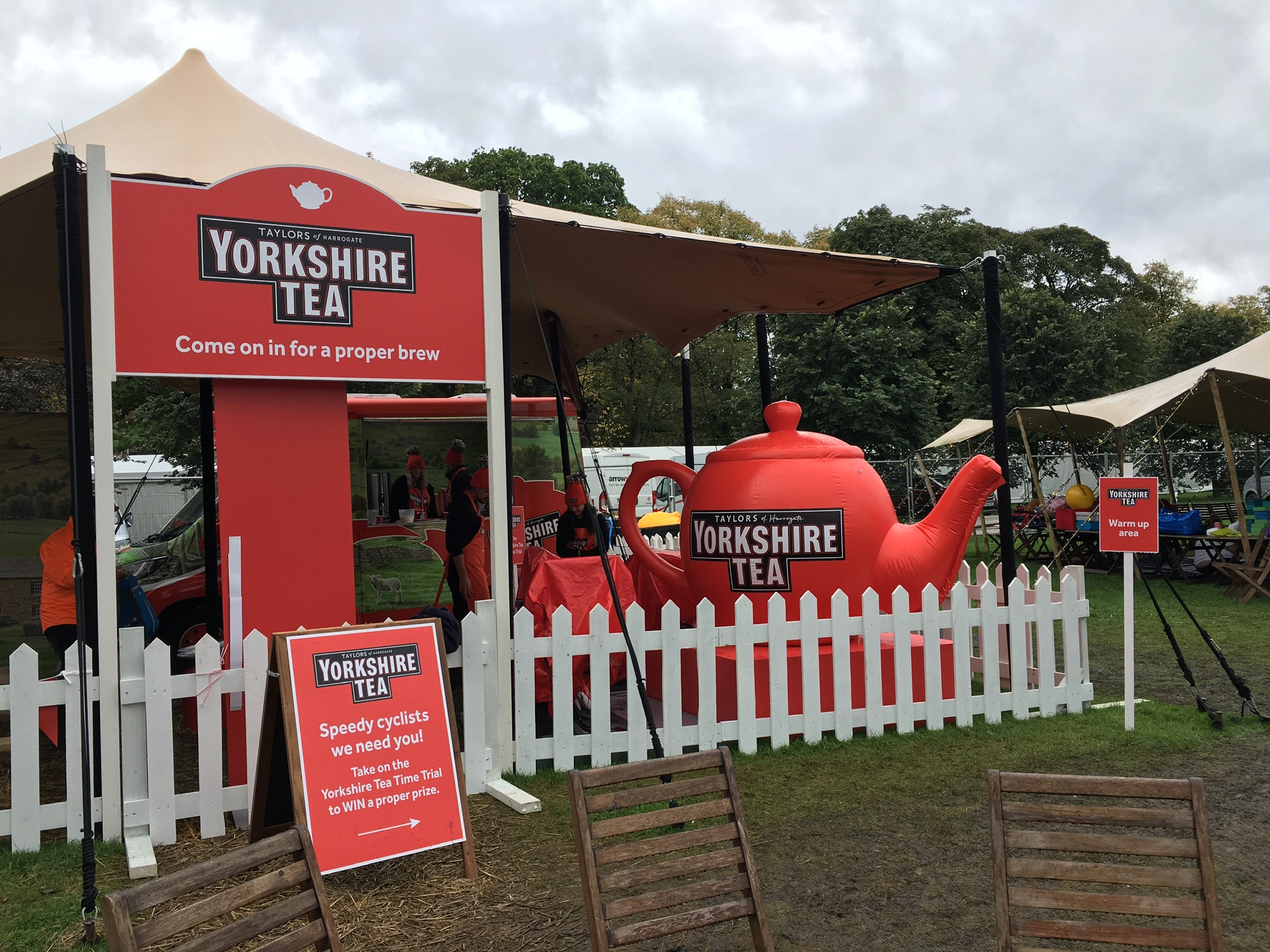 A Yorkshire Tea / Taylors of Harrogate branded pop-up event on the Stray in Harrogate — branded signage, white picket fence, and a giant red teapot.