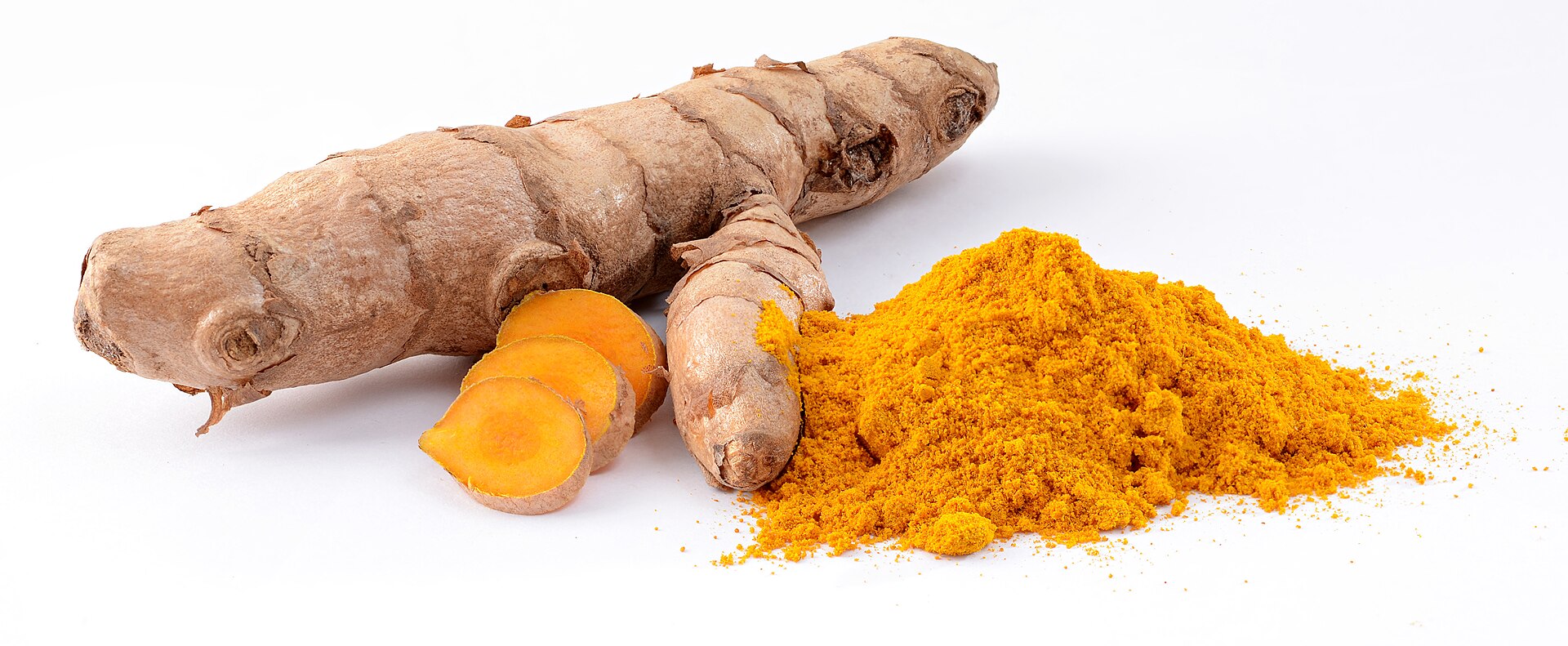 Fresh turmeric rhizomes, one cut open to show bright orange flesh, beside a pile of ground turmeric powder on a white background.