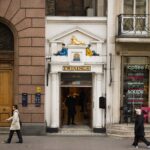 The narrow white Twinings shopfront on the Strand in London with a gold lion above the door.